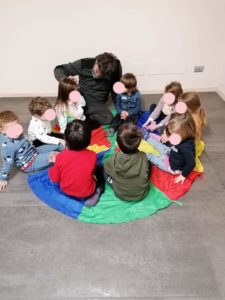 Photo showing a teacher teaching how sound is produced to children